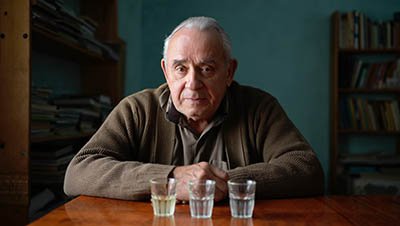 Пожилой мужчина распивает алкоголь